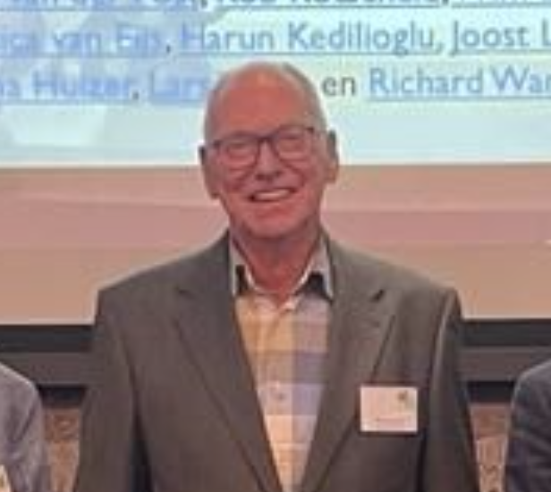 Man in pak lacht naar camera