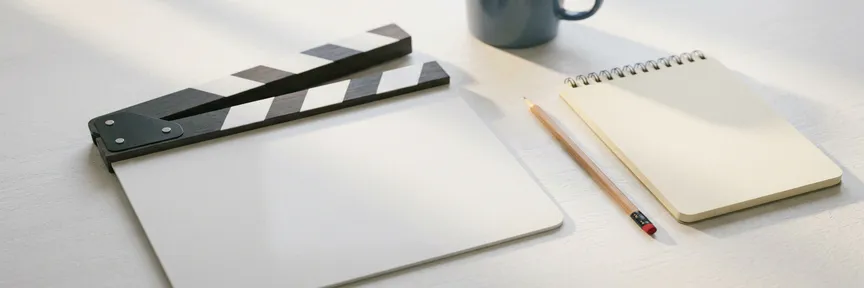 Leeg filmklapper op witte productietafel met geslepen potlood en notitieboek, zacht ochtendlicht, bovenaanzicht.