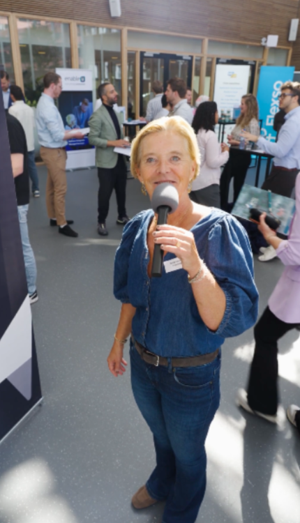 Vrouw met microfoon kijkt in camera