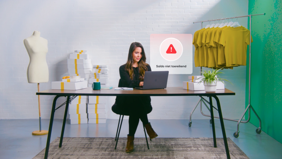 Mevrouw zit in een studio te werken achter de laptop
